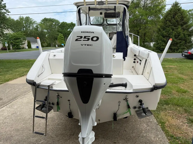 Slide: The Image of 2001 Boston Whaler 23 Conquest with Honda 250 VTEC outboard motor, parked on driveway. - 3