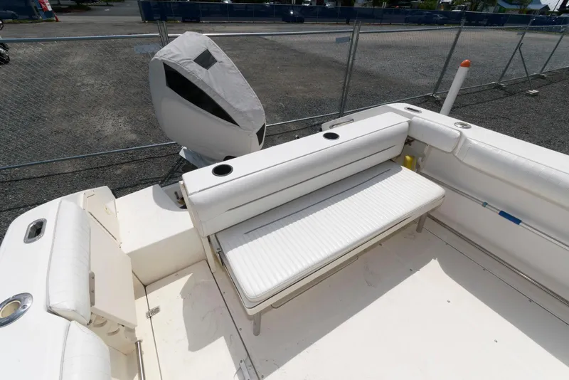 Slide: The Image of 2001 Boston Whaler 23 Conquest boat interior with cushioned seating and covered outboard motor. - 5