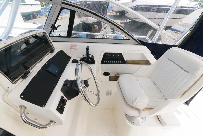 Slide: The Image of 2001 Boston Whaler 23 Conquest helm with steering wheel and captain's chair. - 9