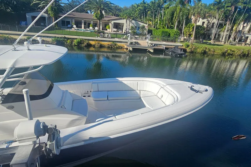Slide: The Image of 2015 Intrepid 327 Center Console boat docked by a scenic waterfront. - 15