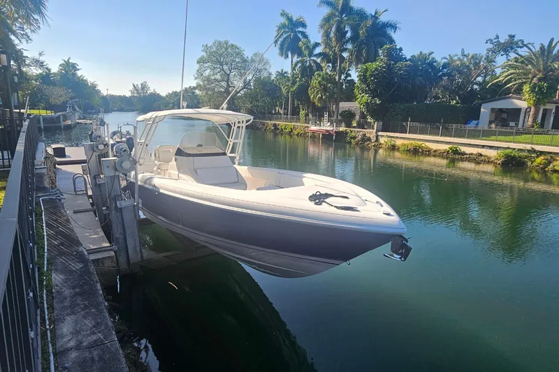 Slide: The Image of 2015 Intrepid 327 Center Console boat docked by a scenic canal. - 2