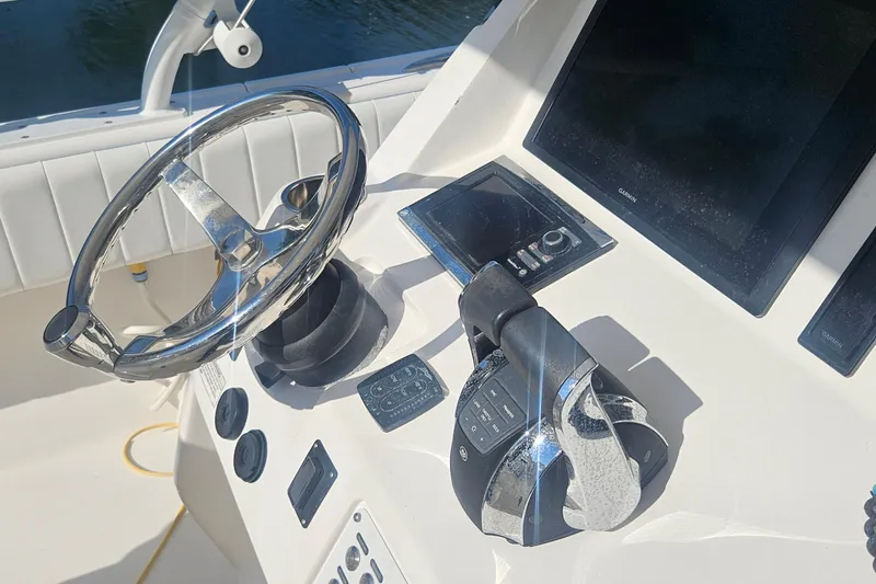 Slide: The Image of 2015 Intrepid 327 Center Console boat dashboard with steering wheel and controls. - 20