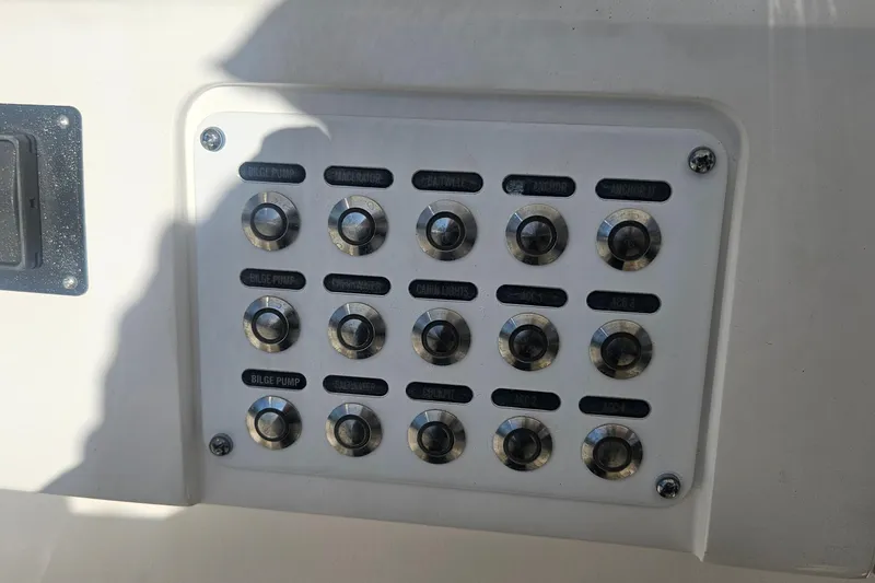 Slide: The Image of Control panel on a 2015 Intrepid 327 Center Console boat with labeled switches. - 24