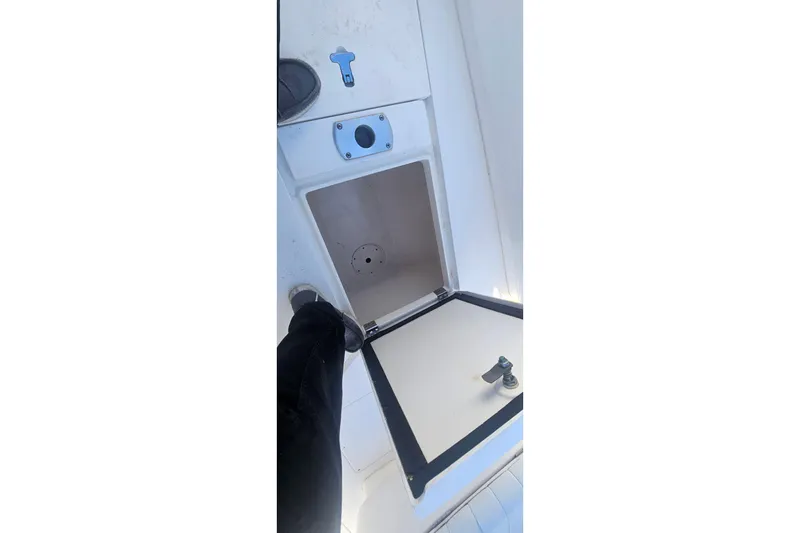 Slide: The Image of Open storage compartment on 2015 Intrepid 327 Center Console boat deck. - 26