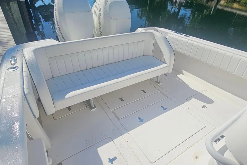Slide: The Image of 2015 Intrepid 327 Center Console boat interior with white seating and dual engines. - 6
