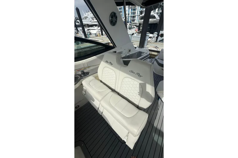 Slide: The Image of 2021 Sea Ray Sundancer 320 interior with white leather seating at marina. - 11