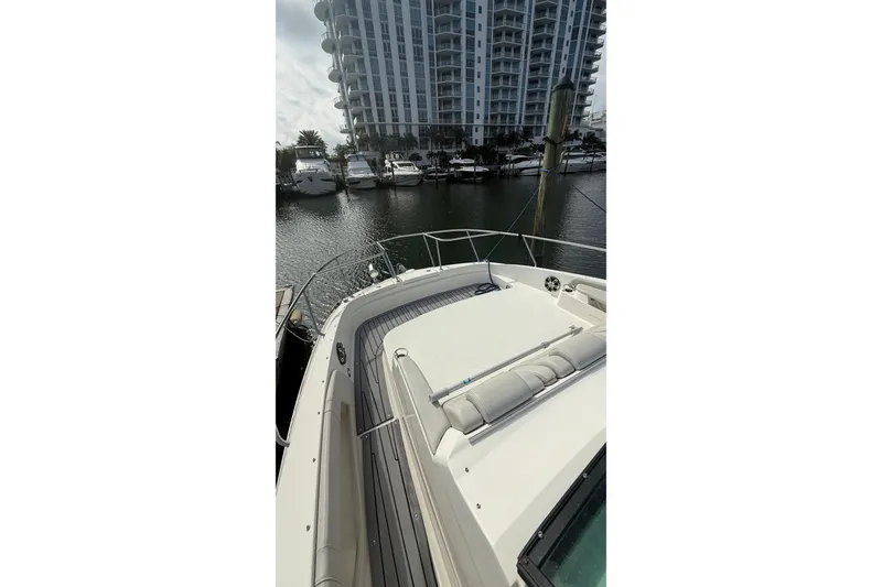 Slide: The Image of 2021 Sea Ray Sundancer 320 yacht docked near waterfront high-rise buildings. - 12