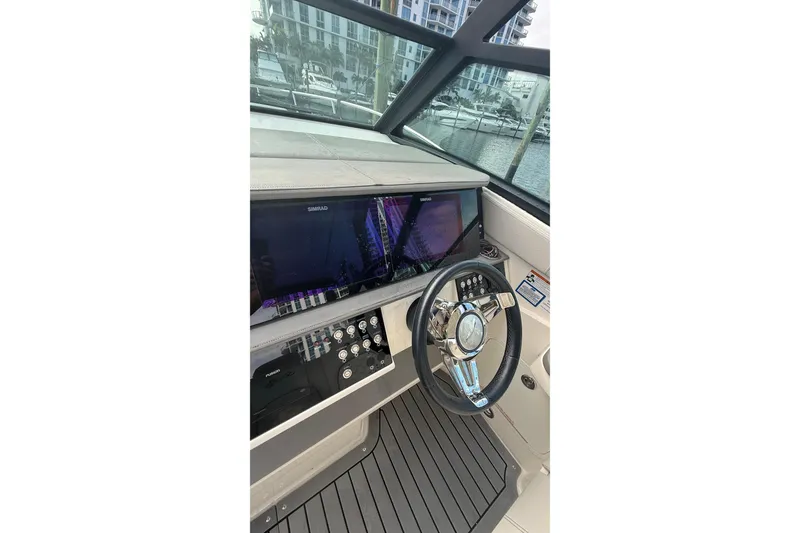 Slide: The Image of 2021 Sea Ray Sundancer 320 helm with modern controls and navigation display. - 13