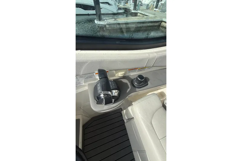 Slide: The Image of 2021 Sea Ray Sundancer 320 helm controls with joystick and throttle, docked at marina. - 14