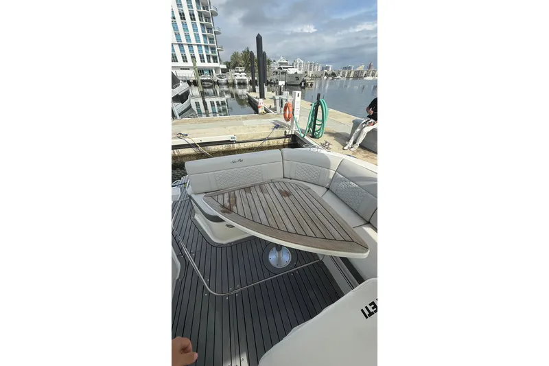 Slide: The Image of 2021 Sea Ray Sundancer 320 yacht interior with wooden table and seating at marina. - 17
