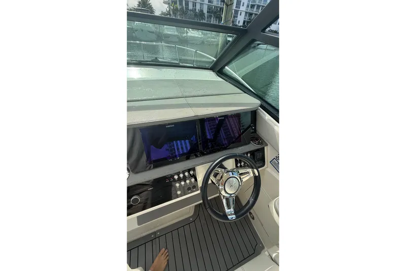 Slide: The Image of 2021 Sea Ray Sundancer 320 helm with modern controls and steering wheel. - 29