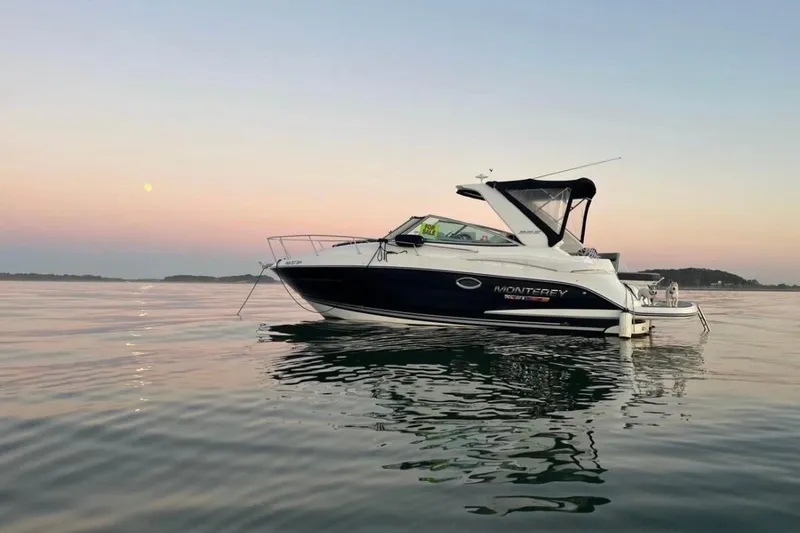 The Image of 2021 Monterey 295 Sport Yacht on calm water at sunset. - 0