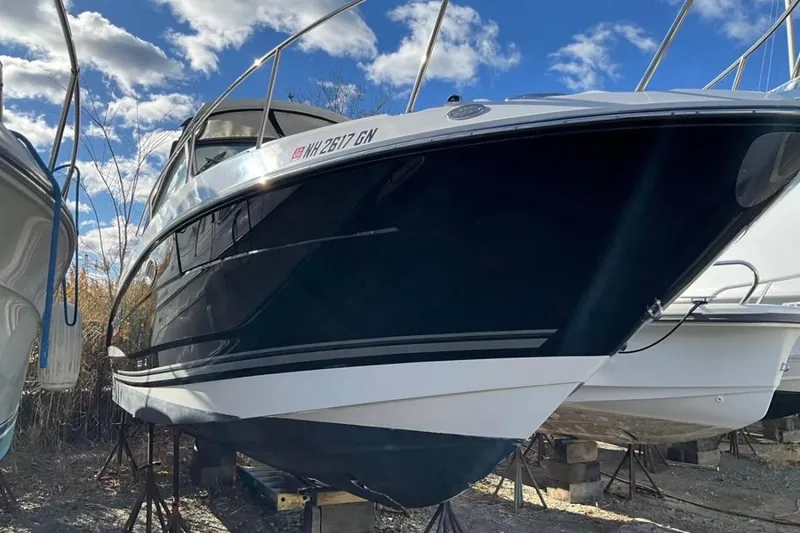 Slide: The Image of 2021 Monterey 295 Sport Yacht on stands under a partly cloudy sky. - 1