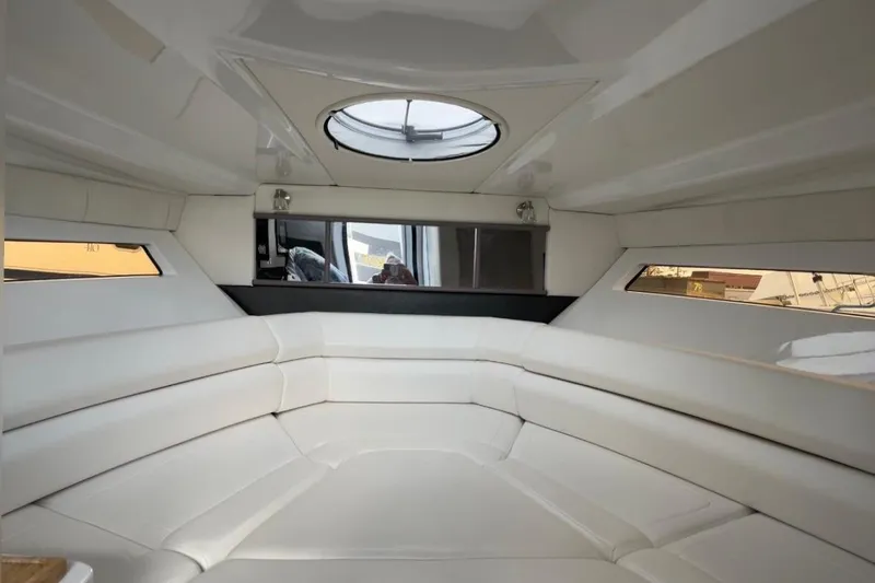 Slide: The Image of Interior of 2021 Monterey 295 Sport Yacht with white seating and circular skylight. - 12