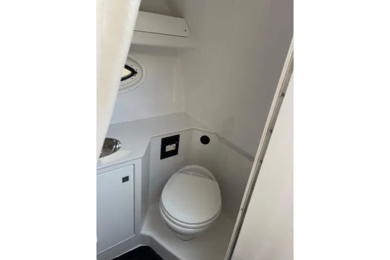 Slide: The Image of 2021 Monterey 295 Sport Yacht bathroom with toilet and sink. - 15