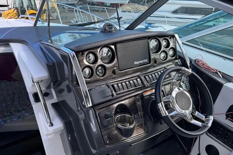 Slide: The Image of 2021 Monterey 295 Sport Yacht dashboard with steering wheel and navigation controls. - 6