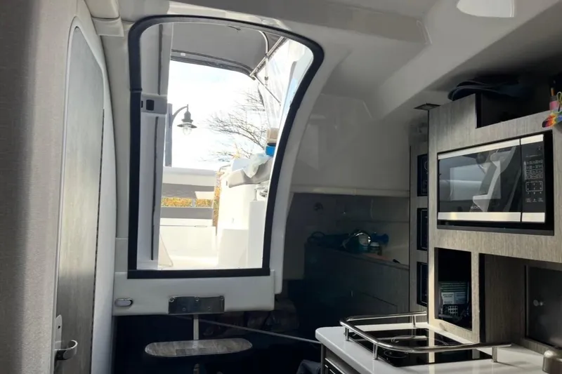 Slide: The Image of Interior view of 2021 Monterey 295 Sport Yacht with modern kitchen amenities. - 7