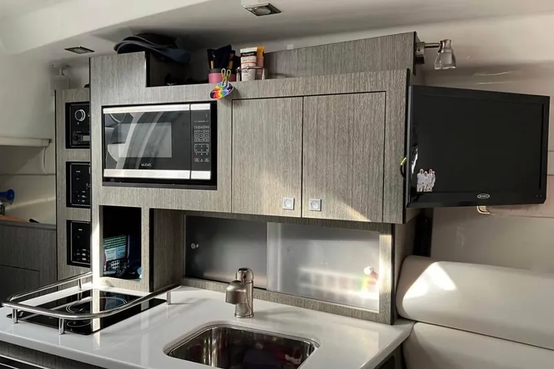 Slide: The Image of Modern kitchen in 2021 Monterey 295 Sport Yacht with microwave, stove, and sink. - 8