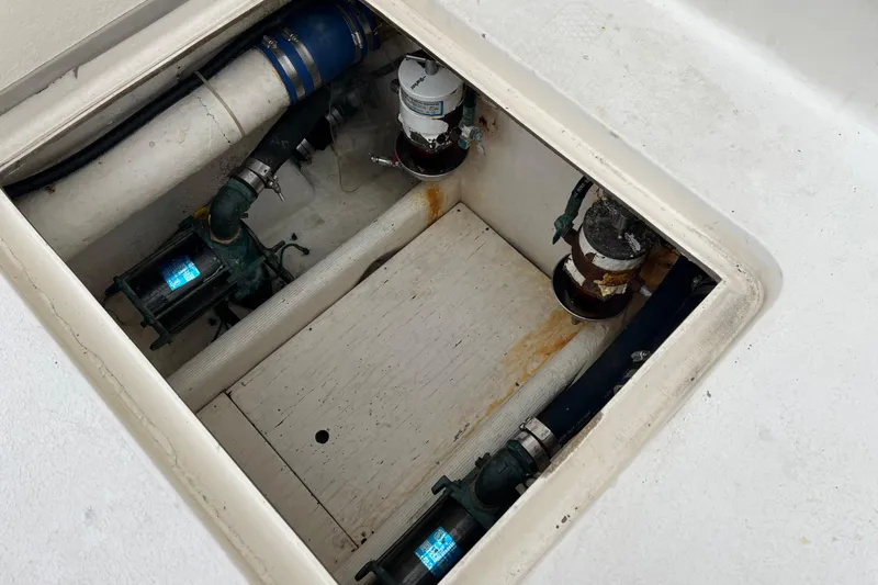 Slide: The Image of Bilge compartment of a 1996 Henriques 28 Express boat, showing pumps and piping. - 10
