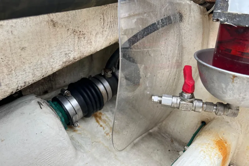 Slide: The Image of 1996 Henriques 28 Express boat engine compartment with valve and hose connections. - 12