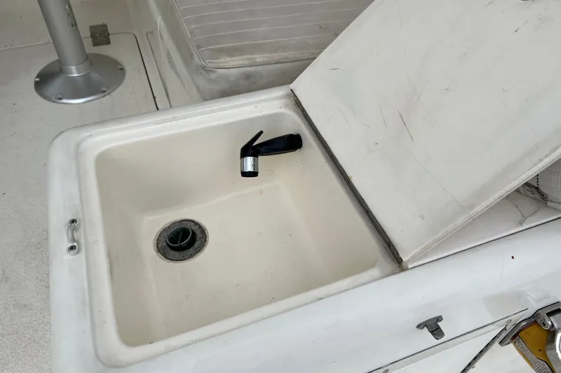Slide: The Image of Open storage compartment on 1996 Henriques 28 Express boat with faucet and drain. - 15