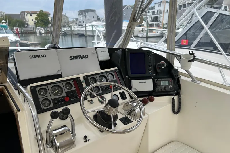 Slide: The Image of 1996 Henriques 28 Express boat helm with Simrad navigation system and steering wheel. - 18