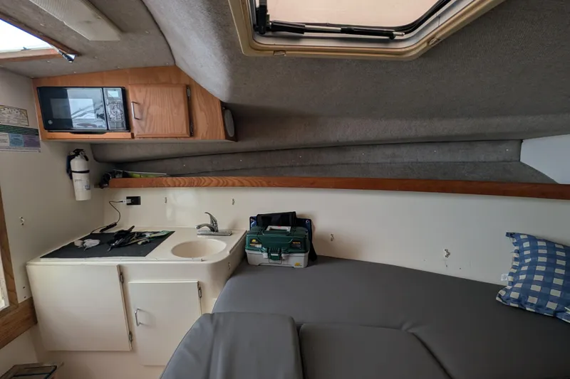 Slide: The Image of Interior of a 1996 Henriques 28 Express boat with kitchenette and seating area. - 24