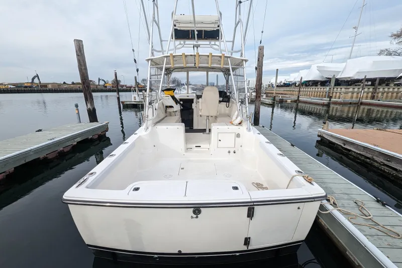 Slide: The Image of 1996 Henriques 28 Express boat docked at marina, rear view showing spacious deck. - 3
