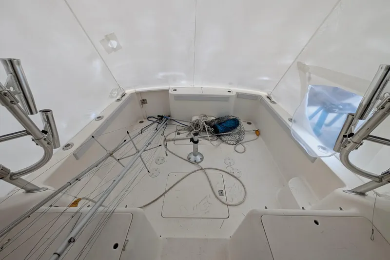 Slide: The Image of Interior view of a 1996 Henriques 28 Express boat, featuring fishing gear and equipment. - 5
