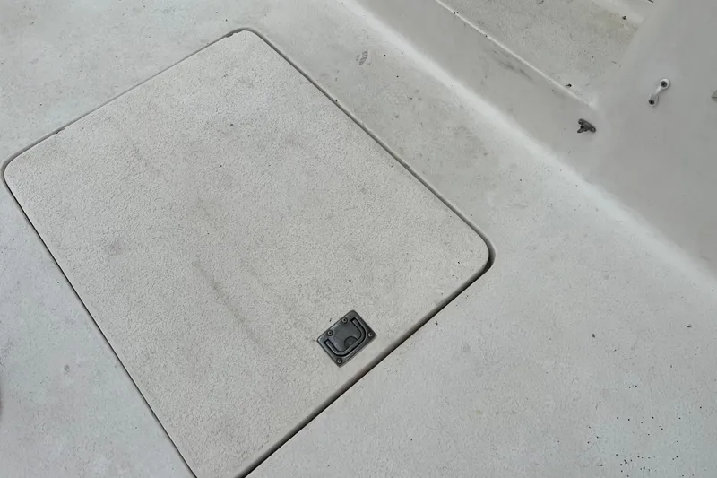 Slide: The Image of Deck hatch on a 1996 Henriques 28 Express boat, featuring a textured surface and latch. - 9