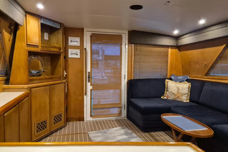 Slide: The Image of Interior of a 1995 Bertram 43 Convertible yacht with cozy seating and wooden accents. - 3