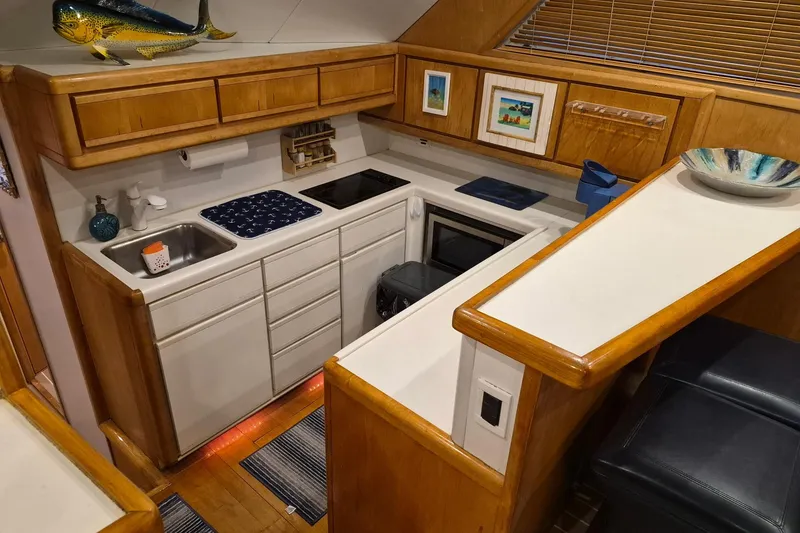 Slide: The Image of 1995 Bertram 43 Convertible yacht kitchen with wooden cabinets and modern appliances. - 6