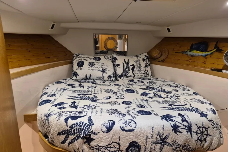 Slide: The Image of Cozy bedroom in 1995 Bertram 43 Convertible yacht with nautical-themed bedding. - 7