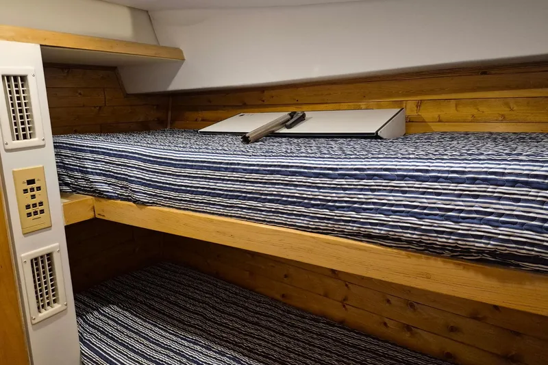 Slide: The Image of Bunk beds with striped bedding in a 1995 Bertram 43 Convertible yacht cabin. - 8
