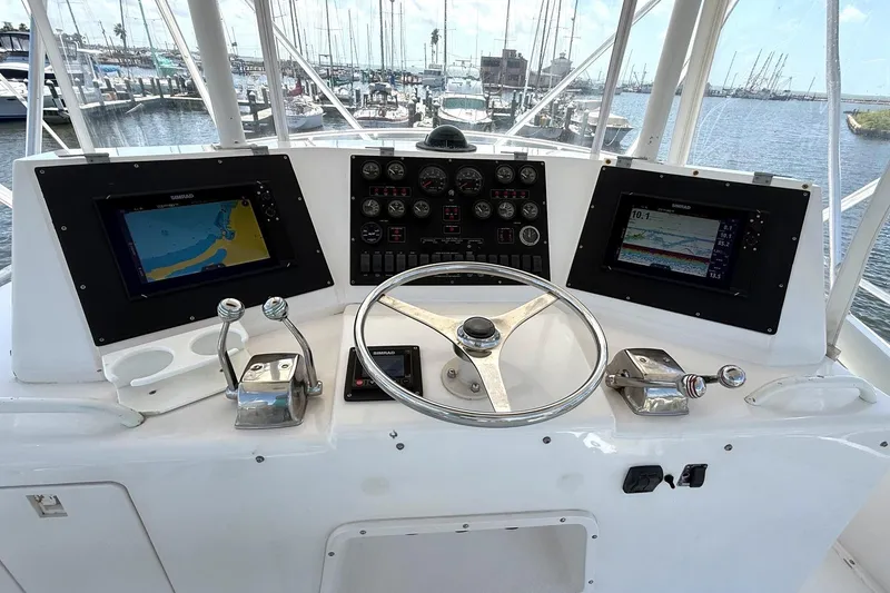 Slide: The Image of 1995 Bertram 43 Convertible helm with navigation screens and controls at marina. - 3