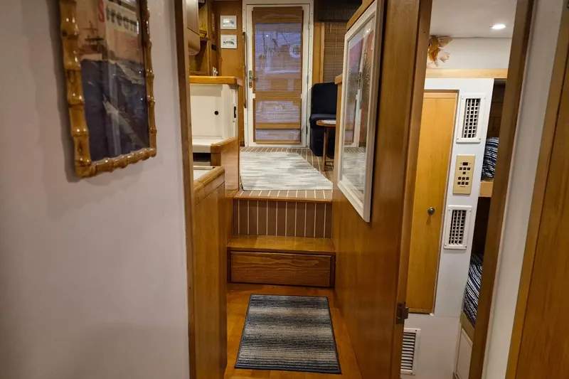Slide: The Image of Interior of a 1995 Bertram 43 Convertible yacht with wooden finishes and cozy decor. - 9