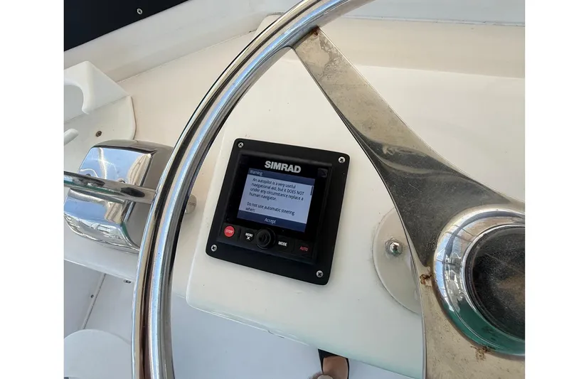 Slide: The Image of 1995 Bertram 43 Convertible helm with Simrad autopilot display and steering wheel. - 8