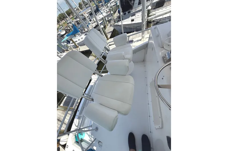 Slide: The Image of 1995 Bertram 43 Convertible yacht interior with white seating at marina. - 10