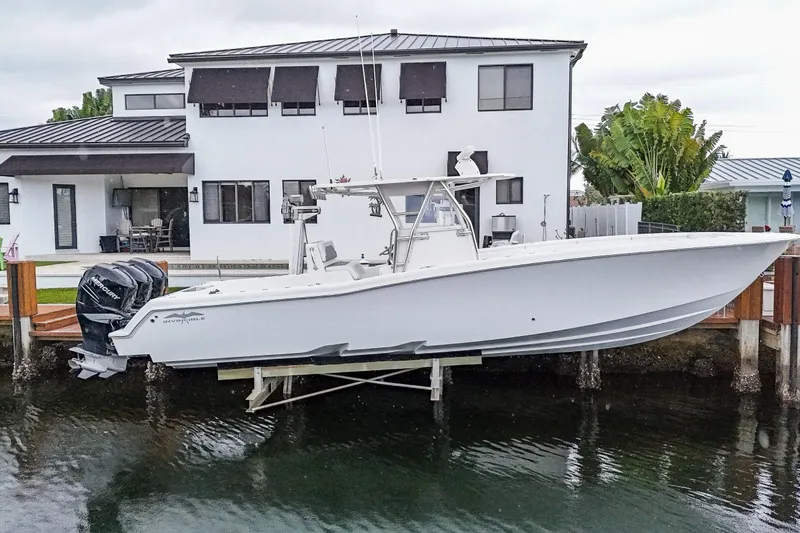 Slide: The Image of 2016 Invincible 36 Open Fisherman boat docked near a modern waterfront home. - 1