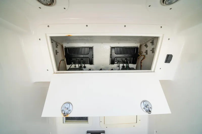 Slide: The Image of 2016 Invincible 36 Open Fisherman electronics compartment with Garmin equipment. - 12