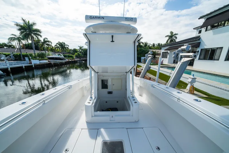 Slide: The Image of 2016 Invincible 36 Open Fisherman boat docked by a canal, featuring Garmin electronics. - 9