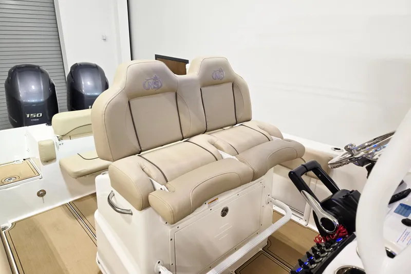 Slide: The Image of 2018 NauticStar 25 XS boat interior with dual seats and control panel. - 14