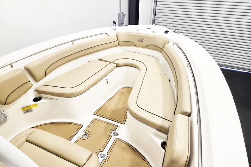 Slide: The Image of 2018 NauticStar 25 XS boat interior with beige cushioned seating and wood accents. - 17