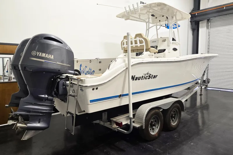 Slide: The Image of 2018 NauticStar 25 XS boat with Yamaha engine on trailer in garage. - 2