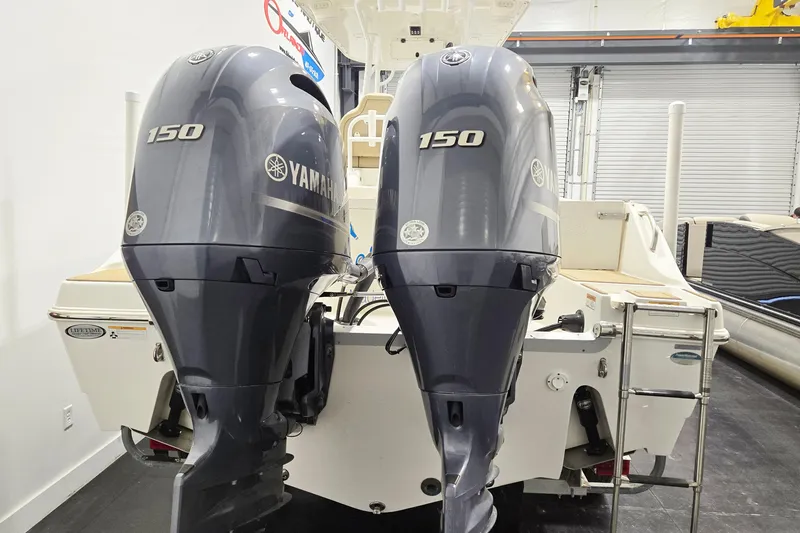 Slide: The Image of 2018 NauticStar 25 XS boat with twin Yamaha 150 outboard engines in a showroom. - 6