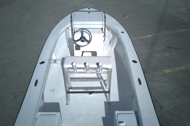 Slide: The Image of 2026 C-Hawk 18 Center Console boat with steering wheel and seating, parked on pavement. - 6