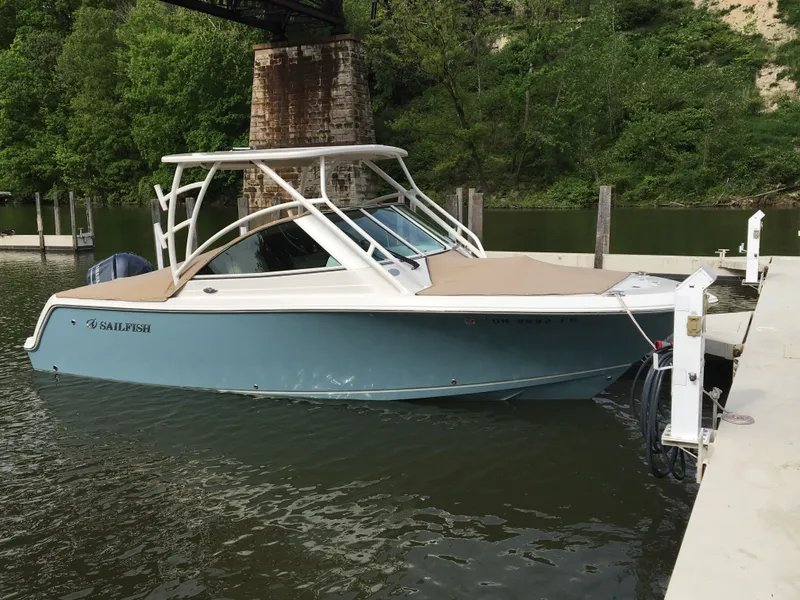 The Image of 2017 Sailfish 245 DC boat docked, surrounded by lush greenery. - 0
