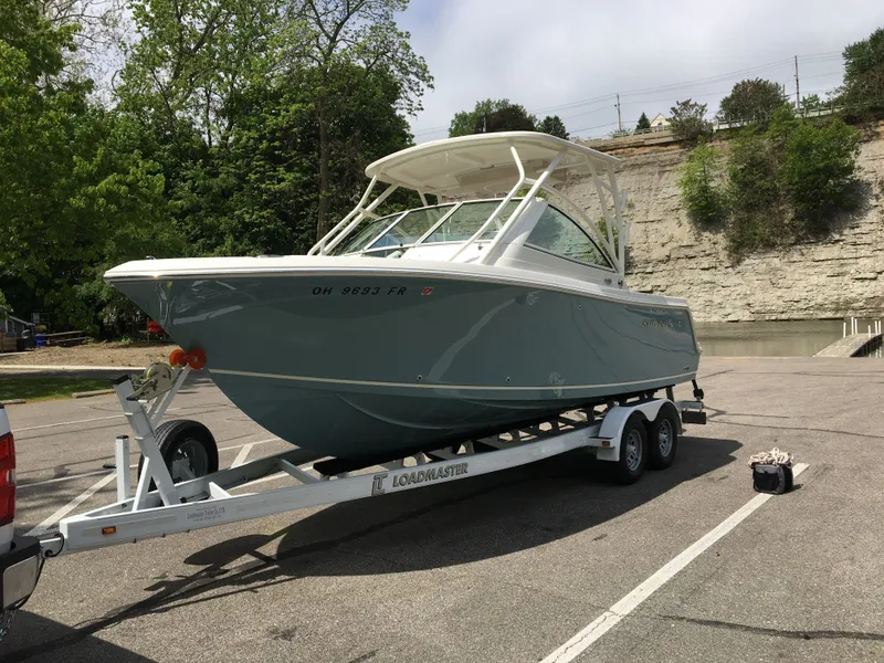 Slide: The Image of 2017 Sailfish 245 DC boat parked on trailer outdoors. - 2