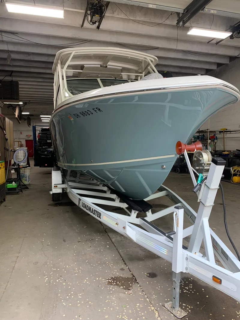 Slide: The Image of 2017 Sailfish 245 DC boat on trailer in garage. - 3