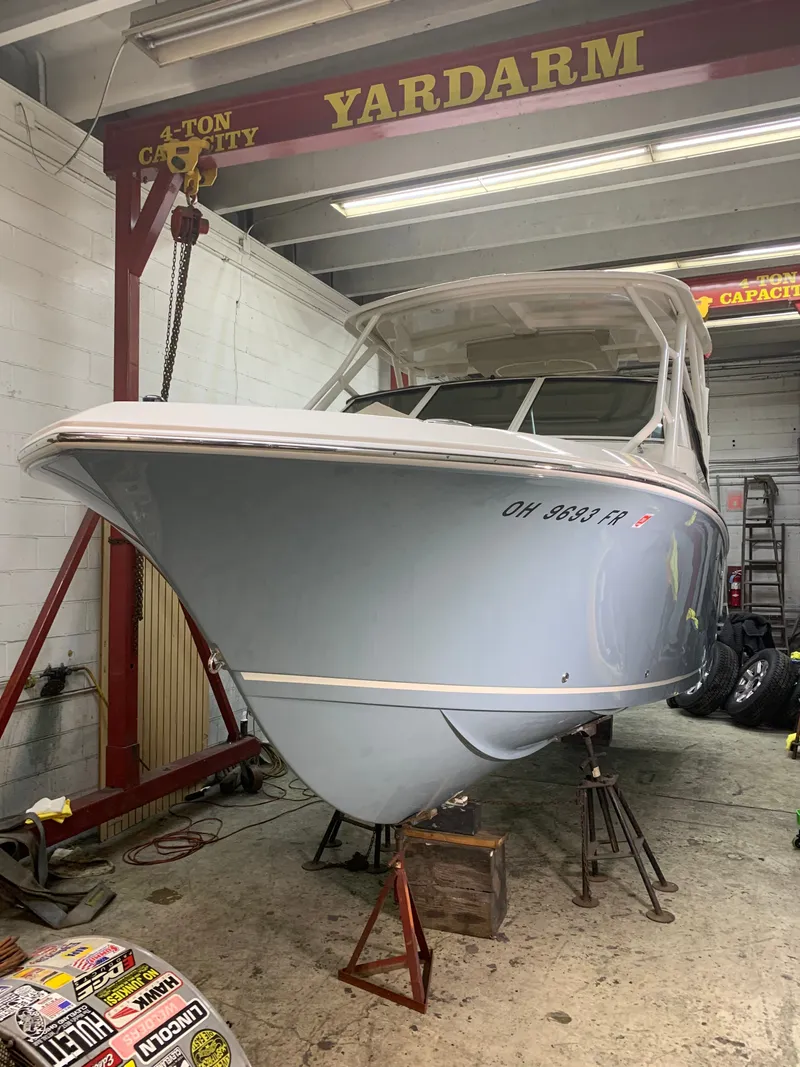 Slide: The Image of 2017 Sailfish 245 DC boat elevated in a workshop. - 4